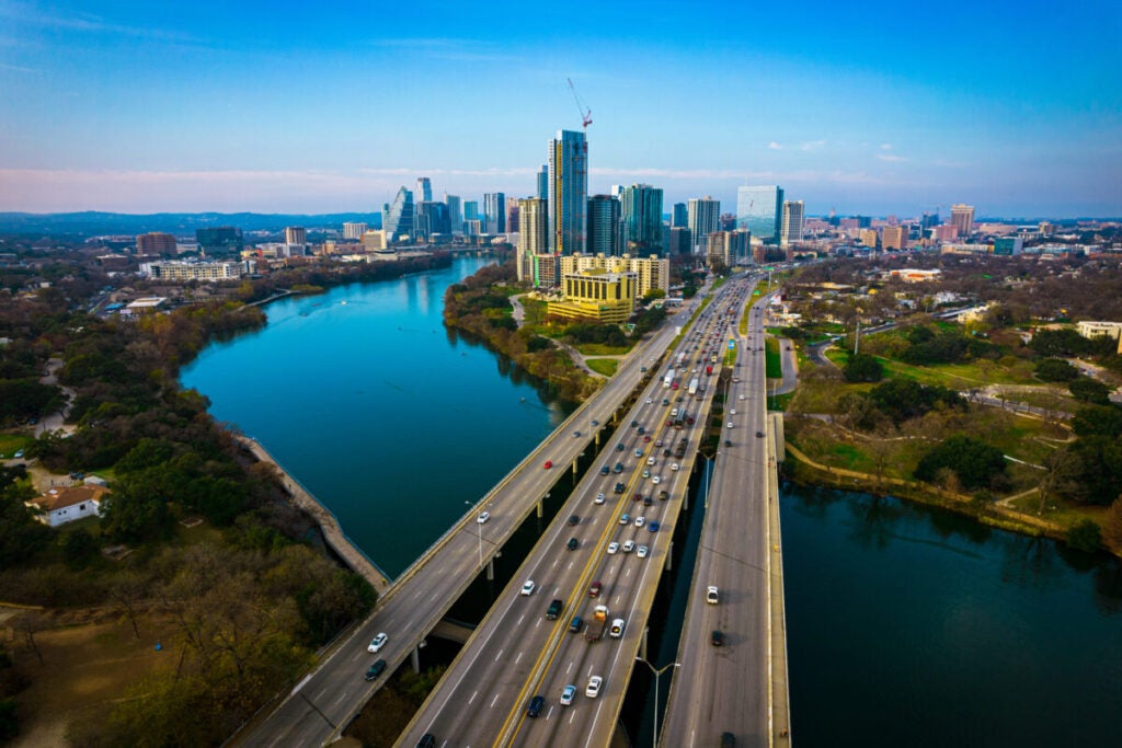 Austin Texas USA a gorgeous capital City of Texas aerial drone views above Coloradp River and Interstate 35 and tall skyscrapers growing Cityscape , traffic , and perfect sunny weather
